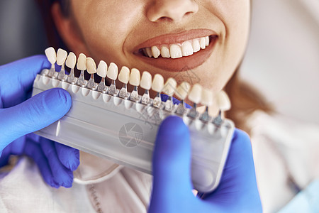 专业医生在现代牙科诊所中选择一种牙齿颜色的牙色化妆品口服程序病人皮肤工作治疗女性蓝色药品图片