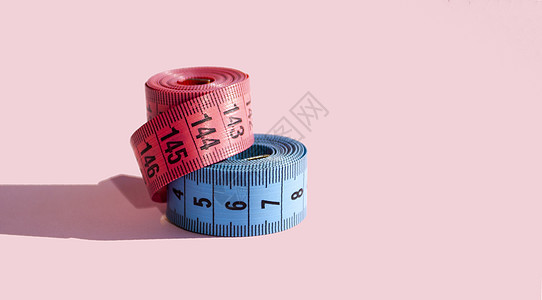 粉红背景的粉色和蓝色摄像带重量尺寸工具仪表观念测量数字白色损失乐器图片