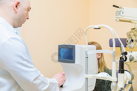 一名男性眼科医生使用现代视力测试器检查一个年轻女孩的视力验光师药品诊所扫描护理眼睛显微镜视网膜测量成人图片