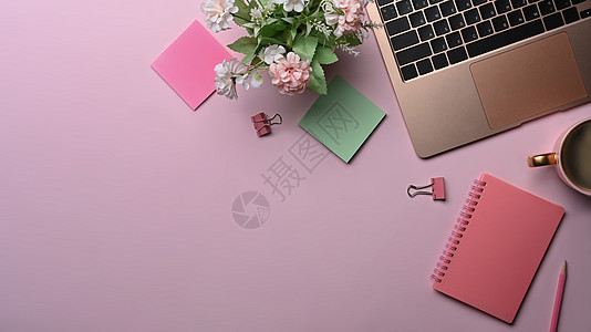 女性工作场所有笔记本电脑 粘贴笔记和粉红色背景的咖啡杯图片