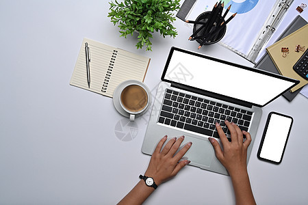 在白色办公桌用笔记本电脑工作的女商务人士的超视线图片