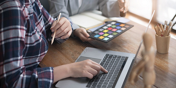 创意平面设计师团队致力于色样样本图表的选择着色灵感 以在工作场所创建新系列项目桌子风暴商务女士会议开发商电脑头脑战略背景图片