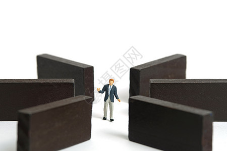 微型人物玩具人物摄影 战略选择概念 耸耸肩的商务人士站在木制迷宫迷宫中间 在白色背景上被隔离图片