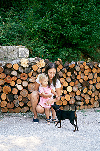 妈妈跟一个小女孩妈妈 在堆柴火附近宠狗图片