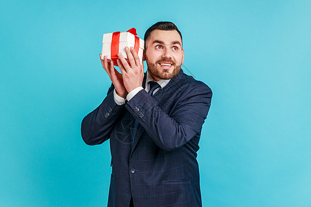 蓝色背景的情感商务人士肖像画 笑声微笑礼品盒男性展示礼物周年商业购物商务礼物盒图片