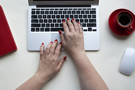 妇女用无线滑鼠 咖啡杯 白桌上笔记本手持手提电脑键盘图片
