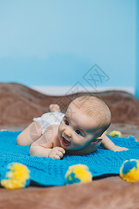 一个四个月快乐的婴儿 躺在一个毛毯上 婴儿肖像 孩子抱着他的头房间新生说谎衣服蓝色身体卧室童年女孩格子图片
