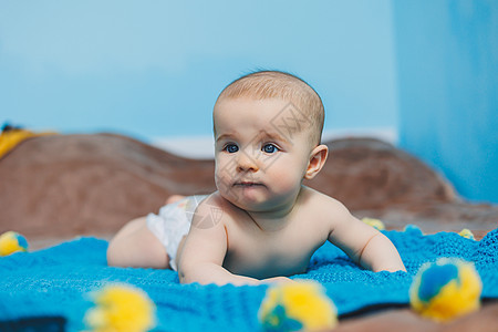 一个四个月快乐的婴儿 躺在一个毛毯上 婴儿肖像 孩子抱着他的头微笑男生寝具房间女孩毯子新生格子婴儿床卧室图片