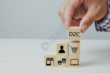 手把直接对消费者D2C的木制立方体放在桌子上 复制空间网络白色工作社会概念日历职业字母技术金融图片