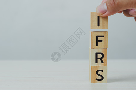 手把木制立方体 IFRS 国际财务报告标准与桌子和复制空间 商业财务概念图片