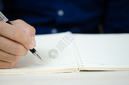 紧紧握着一支笔 写在笔记本上工作家庭作家写作职场经理记事本学生杂志大学图片