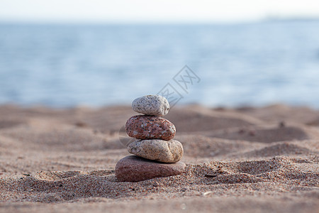 圆石在海边的一纵列中 互相顶着禅意假期金字塔岩石卵石天空海滩蓝色治疗旅行图片