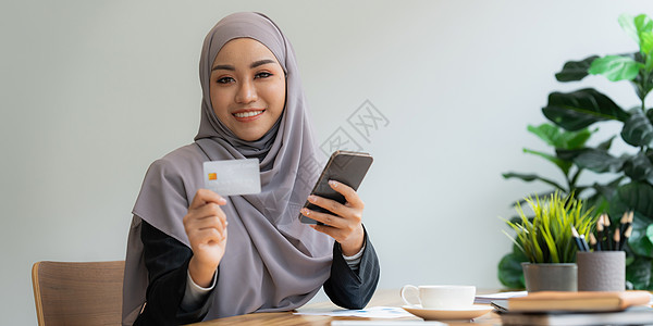 使用信用卡和智能手机进行网上银行付款的年轻女性 网上购物的概念互联网卡片男人键盘基准购物技术女士零售电脑图片