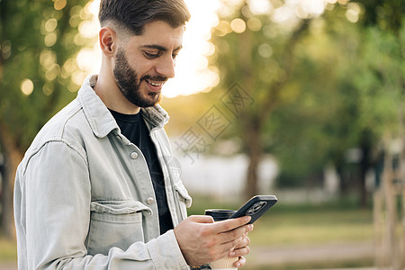 微笑着留着胡子的商务人士手持智能手机站在办公室外 经理 ceo 使用手机移动应用程序 企业发展的数字技术应用和解决方案图片