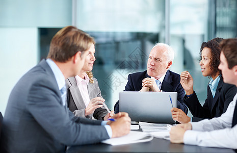 聆听一个有趣的提议 重点高管们在会议期间坐在一张桌子上 用笔记本电脑发言图片