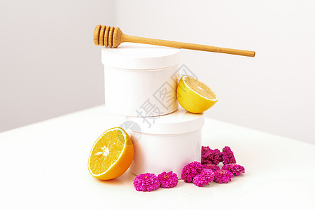 配有木制蜂蜜棒 新鲜柠檬和鲜花的罐子牛奶皮肤身体瓶子卫生水果温泉生物产品洗剂图片