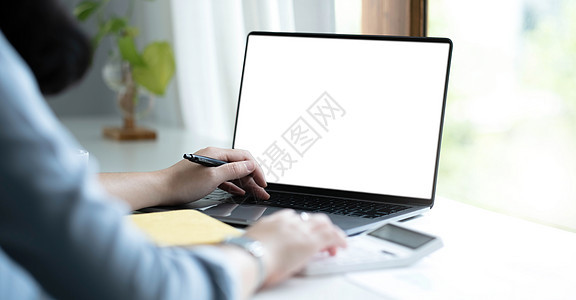一名妇女用笔记本电脑在办公室的木制桌子上使用空白白屏屏幕键盘女孩技术监视器女性商业人士展示女士图片