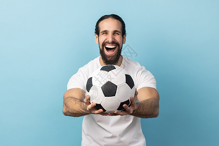 男人手握着足球球 看着摄影机 面部表情激动不已图片