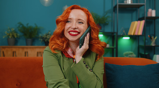 红发女人享受智能电话聊天 手机在家与朋友交谈的爱打情话成功商务技术服装人士自由职业者女孩快乐休息老板图片