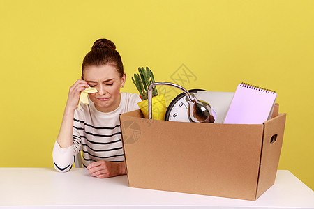 绝望的女办公室工作人员坐在工作场所 带着纸箱和她的东西在哭泣 (笑声)图片