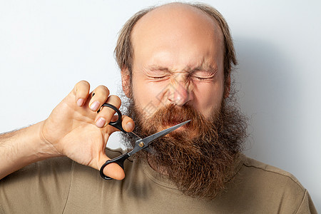 男性剪胡子的肖像 弄坏他的眼睛 感到后悔 把剪刀握在手里图片