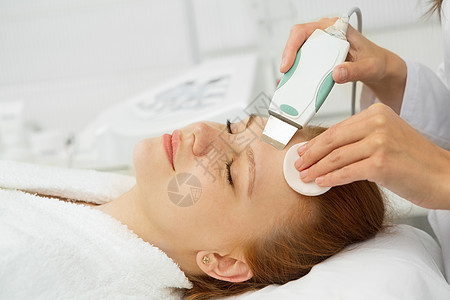 在美容诊所做超声波面部清洗的漂亮女人职业皮肤卫生工作保健程序治疗清洁护理沙龙图片