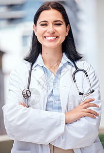自信的年轻女医生双臂交叉站在医疗办公室外 一位身穿白大衣的白人女性拿着听诊器 关爱患者健康的值得信赖的从业者图片