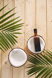 木制背景的椰子和椰子油润肤化妆品玻璃坚果治疗温泉身体擦洗瓶子护理图片
