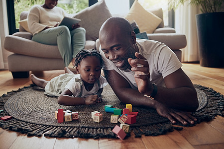 一个小女孩和她父亲 在家里玩砖块游戏的小孩儿和爸爸都摔倒了图片