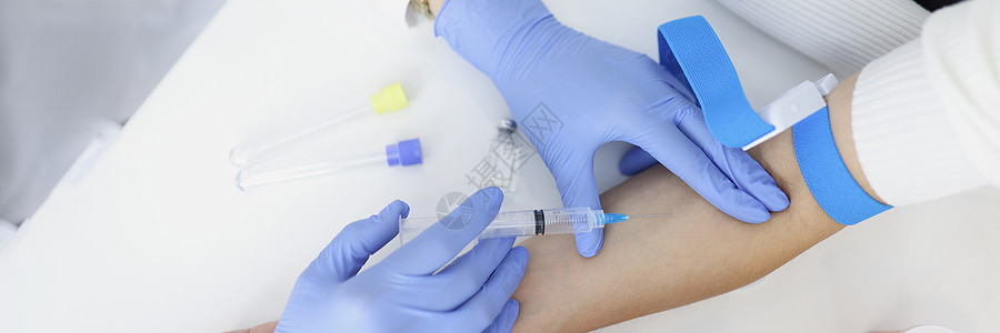 护士用针管注射妇女静脉的液体药物图片