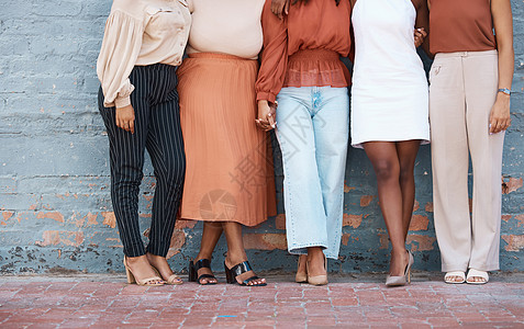 一群五名女商务人士站在城市外面的墙上 从下面一起站在户外的朋友的腿 有爱心的商务人士站在一起图片