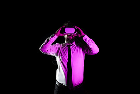 利用虚拟现实眼球和接受专业培训的名人商务人士 轻描淡写在人类经历模拟器上 并展示现代技术商业电脑防护眼镜休闲背光运动男性黑色套装图片
