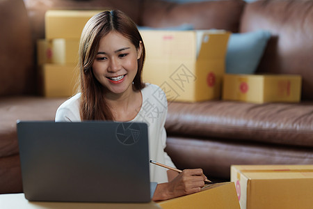 年轻亚洲女性创业自由职业者 包裹盒和电脑笔记本与客户交谈 的图像 在线营销包装箱交付概念 电子信箱纸板女士产品顾客船运企业家送货图片