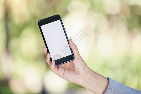 这个应用程序值得大惊小怪 一个不知名的女商务人士拿着一个手机 外出用空白屏幕拍下镜头图片