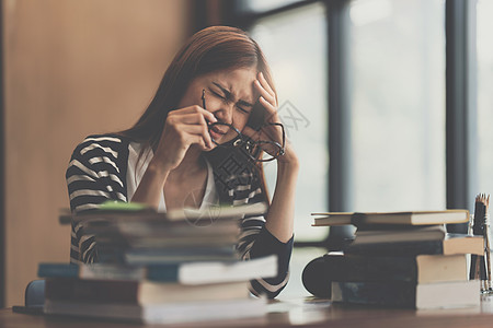 年轻女性在学校阅读图书馆考试的书时 在重回学校概念时被强调的形象问题青少年教育黑板课堂男生桌子粉笔朋友们青年铅笔图片