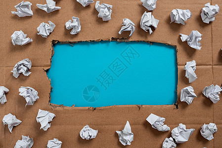 重要信息写在撕开的纸板下 周围用纸包裹 撕破的纸板下的重要公告 上面满是皱巴巴的笔记文档创造力蓝色想像力挫折废纸床单商业材料桌子图片