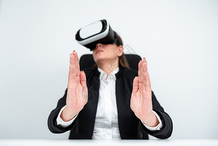 女执行官在职业培训期间穿着虚拟现实模拟器 女商务人士在办公桌上身穿西装并展示未来技术企业家男人科学成人互联网办公室手势电脑计算机图片