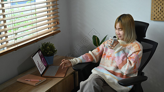 偶尔在家中用笔记本电脑浏览互联网 在咖啡和网络上喝咖啡图片