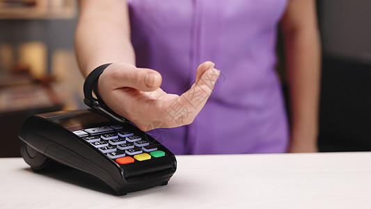 近身 女性使用无现金钱包NFC技术向银行终端支付订单 手机付款图片