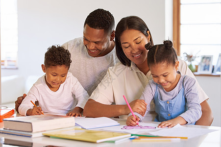 快乐的小孩和父母一起学习和做作业 混血夫妇在家上学学龄前儿子和女儿 西班牙裔父母给孩子们上写作课图片