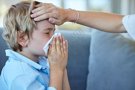 生病的男孩擤鼻涕 母亲感觉儿子在发烧 感冒的小男孩用纸巾擤鼻涕 父母照顾生病的孩子 担心的母亲检查儿子的体温图片