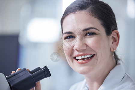充分利用她的设备 一位年轻的女实验室技术人员正在使用她的显微镜图片