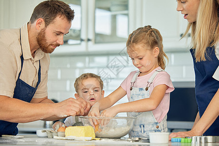 有爱心的白人父母和他们的小女儿在家里的厨房里一起烘烤 妈妈和爸爸在凌乱的厨房里教女儿们如何做面团 学烘焙的姐妹们图片