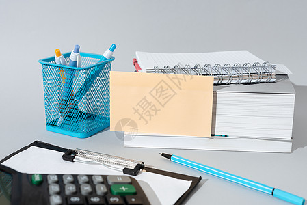 重要消息出现在桌上的便条上 周围有铅笔 书籍 剪贴板和计算器 重要信息显示在带有笔记本和笔的桌子上的备忘录上文书数据办公用品金融图片