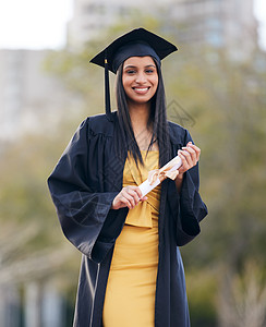 我写到一个大篇章的结尾 一位年轻女子在毕业日持有毕业证书的肖像图片