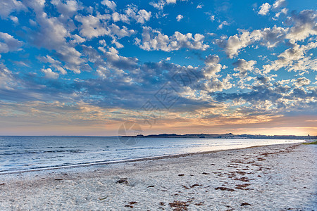 海滩海岸的自然海景和阳光明媚的夏日的海水 充满沙子的海岸和多云的蓝天在地平线上的美丽风景与潮汐和水流图片