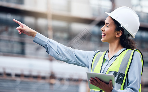 她总是尽职尽责 一位年轻的女建筑师在建筑工地使用数字平板电脑图片