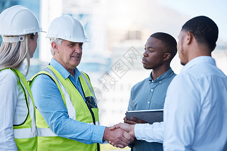 建设一支伟大的团队要忍耐了 一队建筑工人在问候中握着手图片