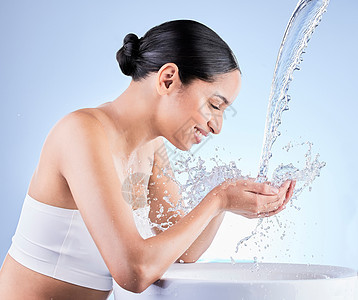 快乐是一种习惯 你的皮肤护理也是一样 一个年轻女人在蓝色背景下洗身时洗澡了图片