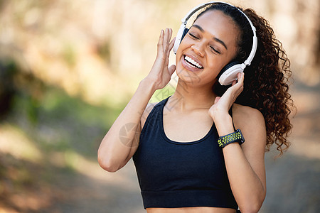 让音乐充斥你的灵魂 一个年轻女人在跑步前 听一些有趣的音乐图片